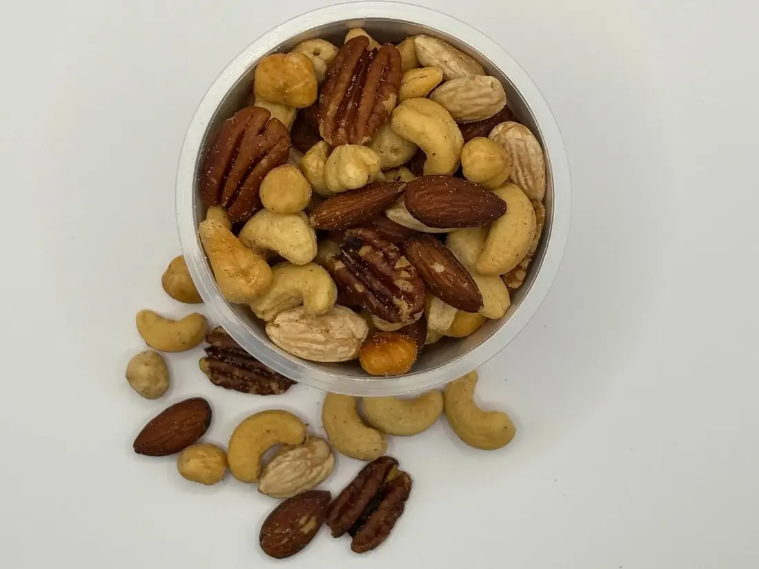 Bowl of mixed nuts on a pale background