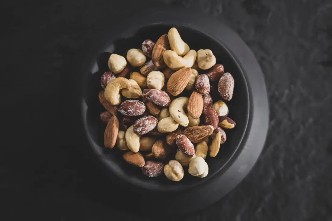 Dark bowl filled with mixed nuts