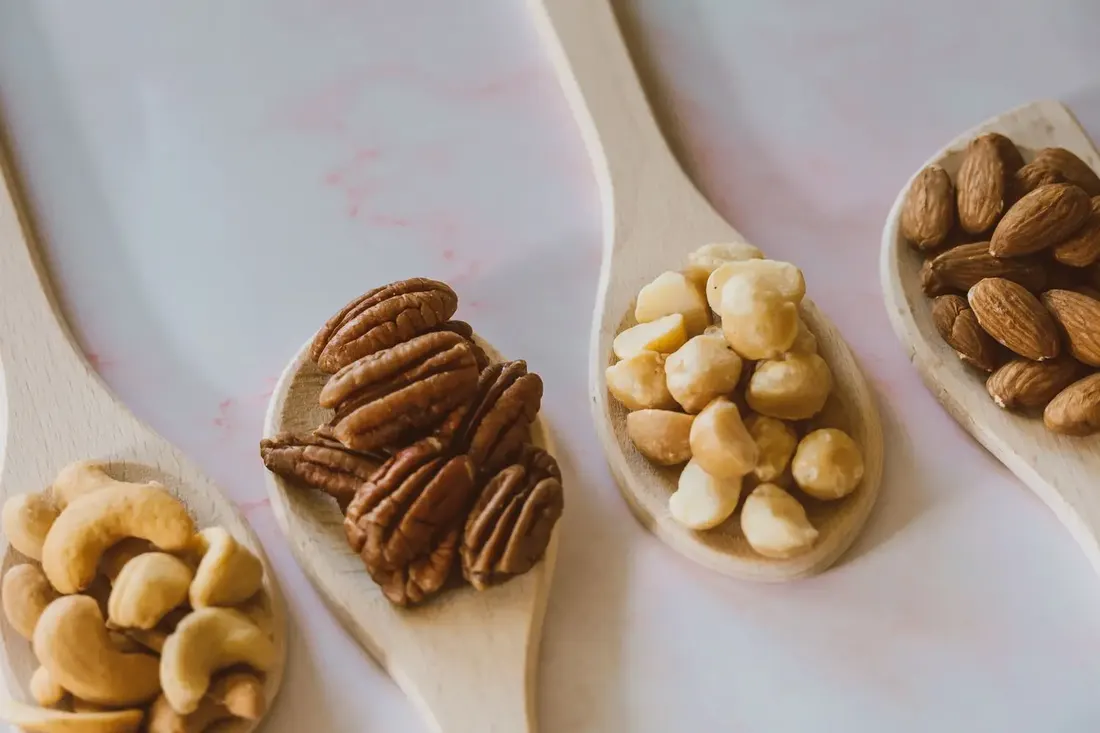 Cashews, pecans and almonds in small ceramic bowls